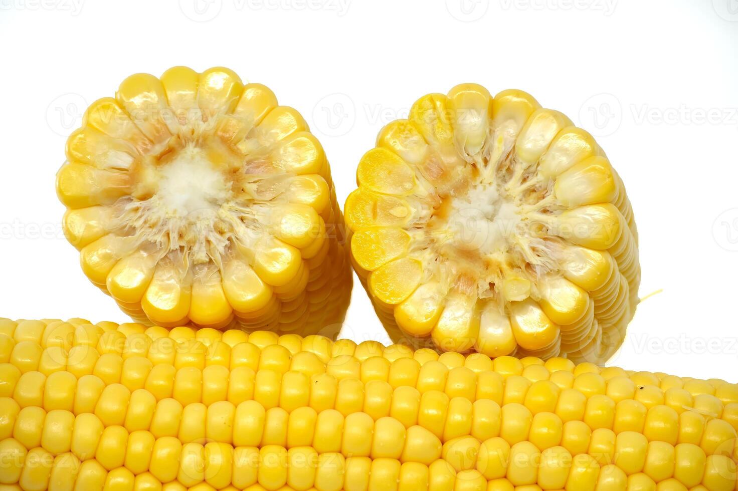 Close-up image of fresh corn cobs arranged on a white background photo