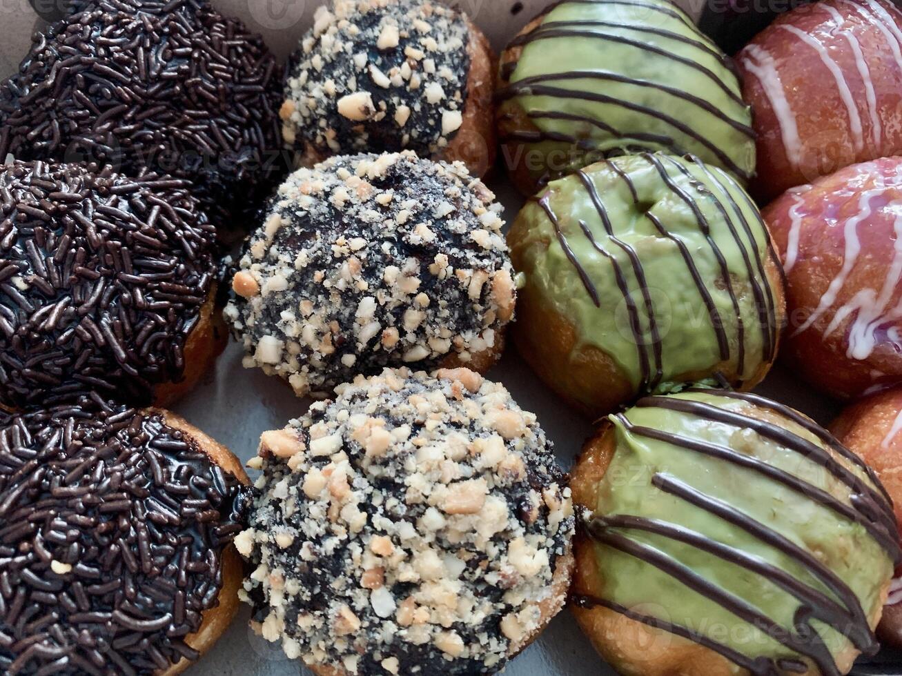 a box of assorted donuts with different toppings. photo