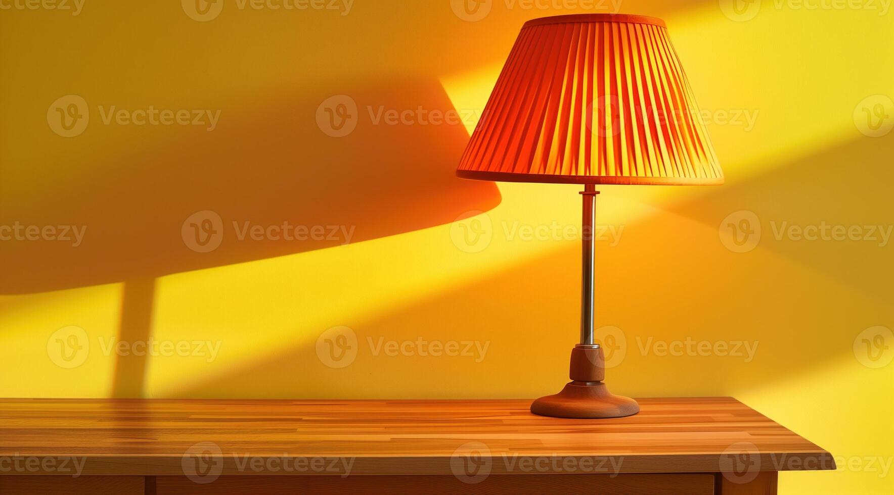 Table lamp with yellow lampshade stands on wooden table. Copyspace. Yellow back photo
