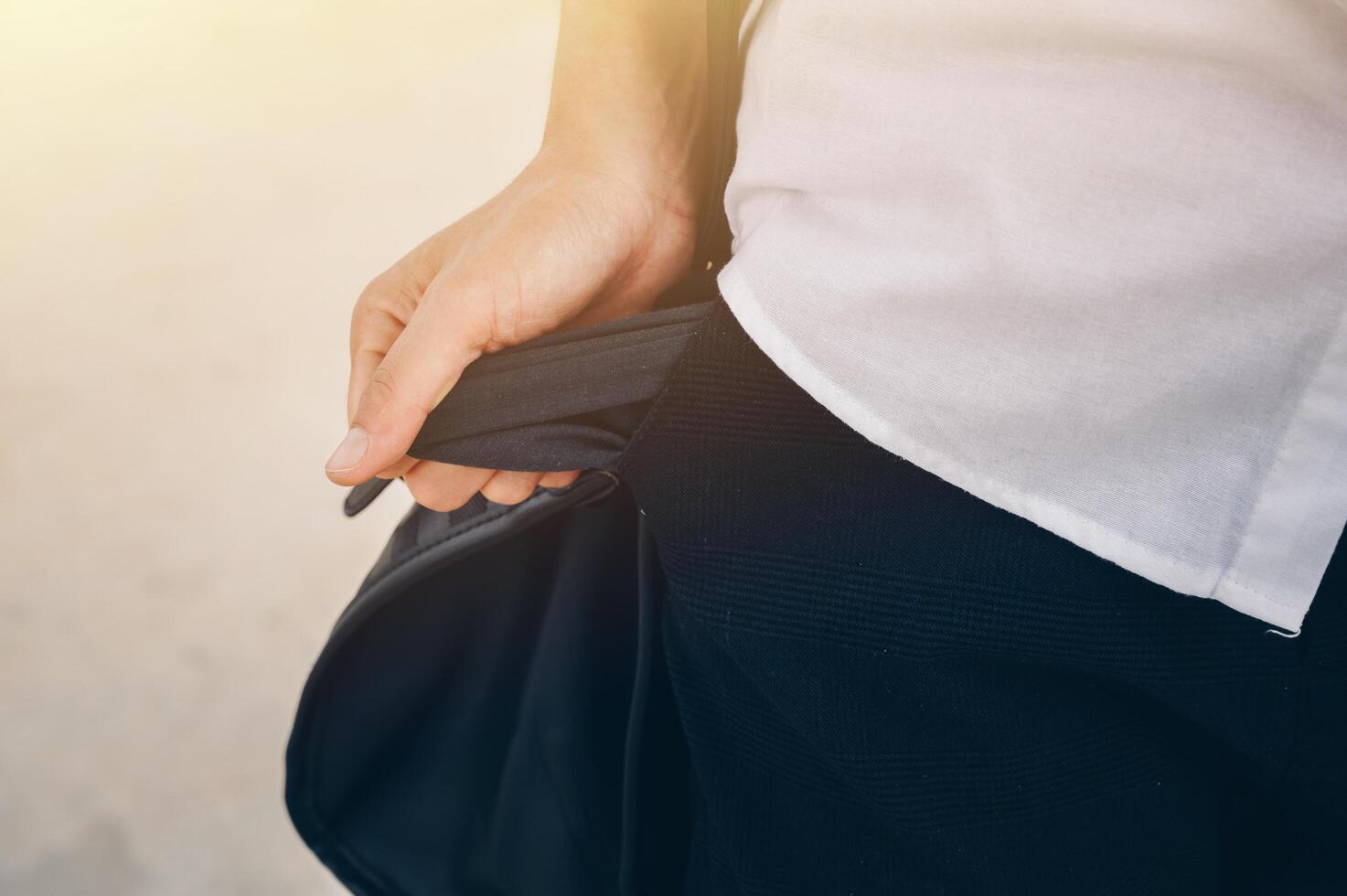 Cropped shot of Businesswoman in white shirt turning out and shows empty pockets of her trousers. photo