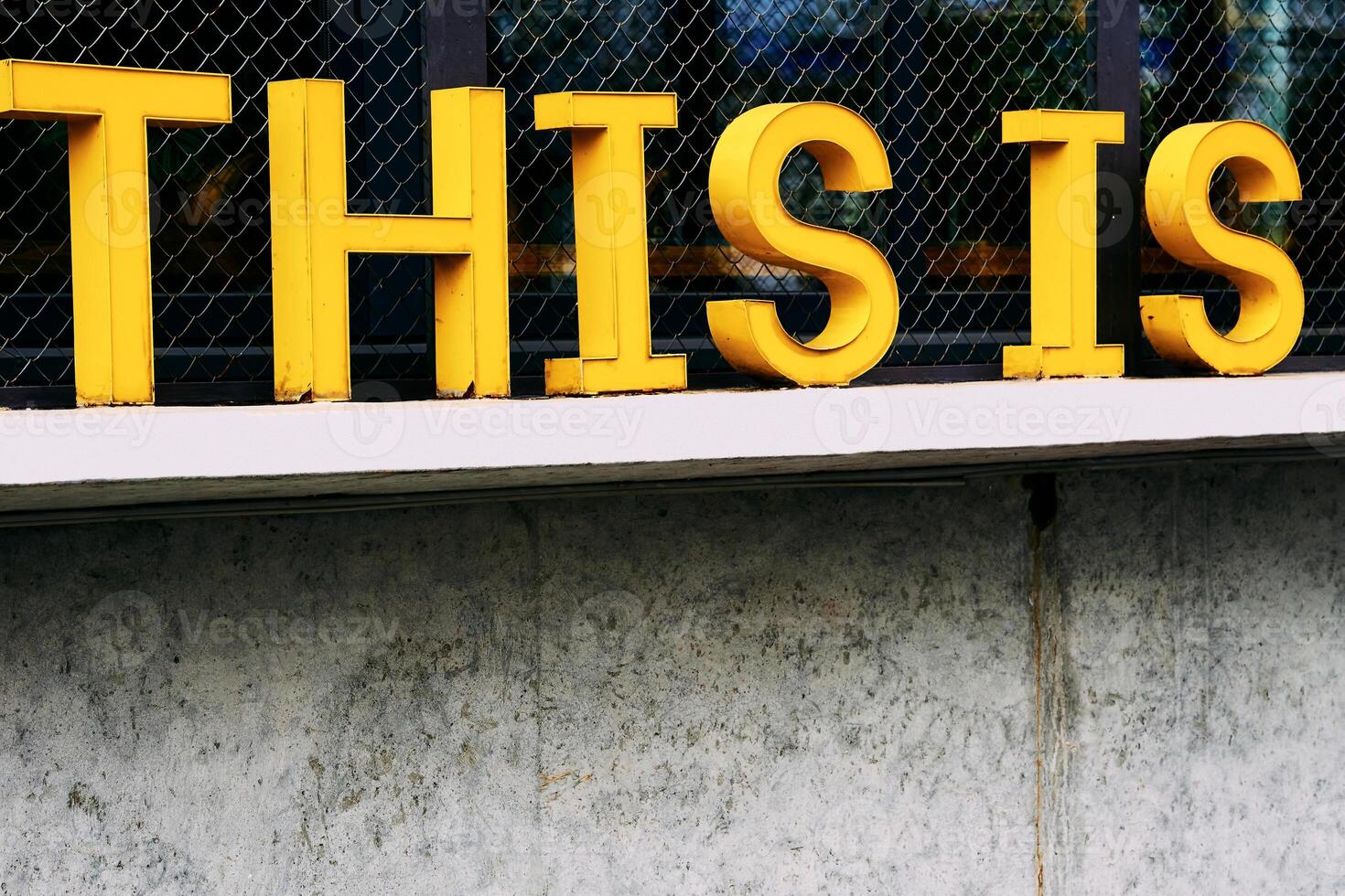 Yellow grunge inscription this is on concrete windowsill photo