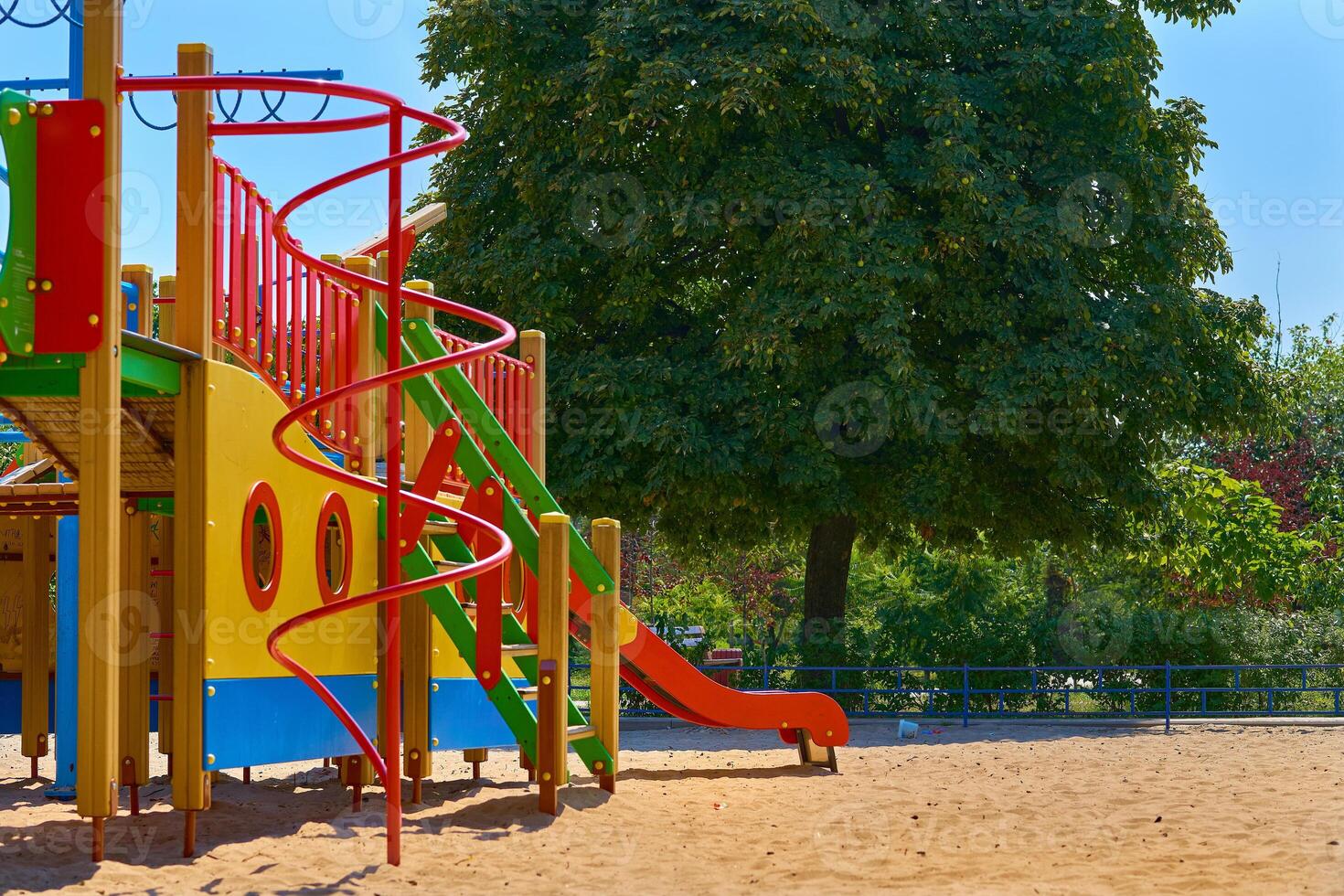 Summer children's playground with painted toy slide in public park photo