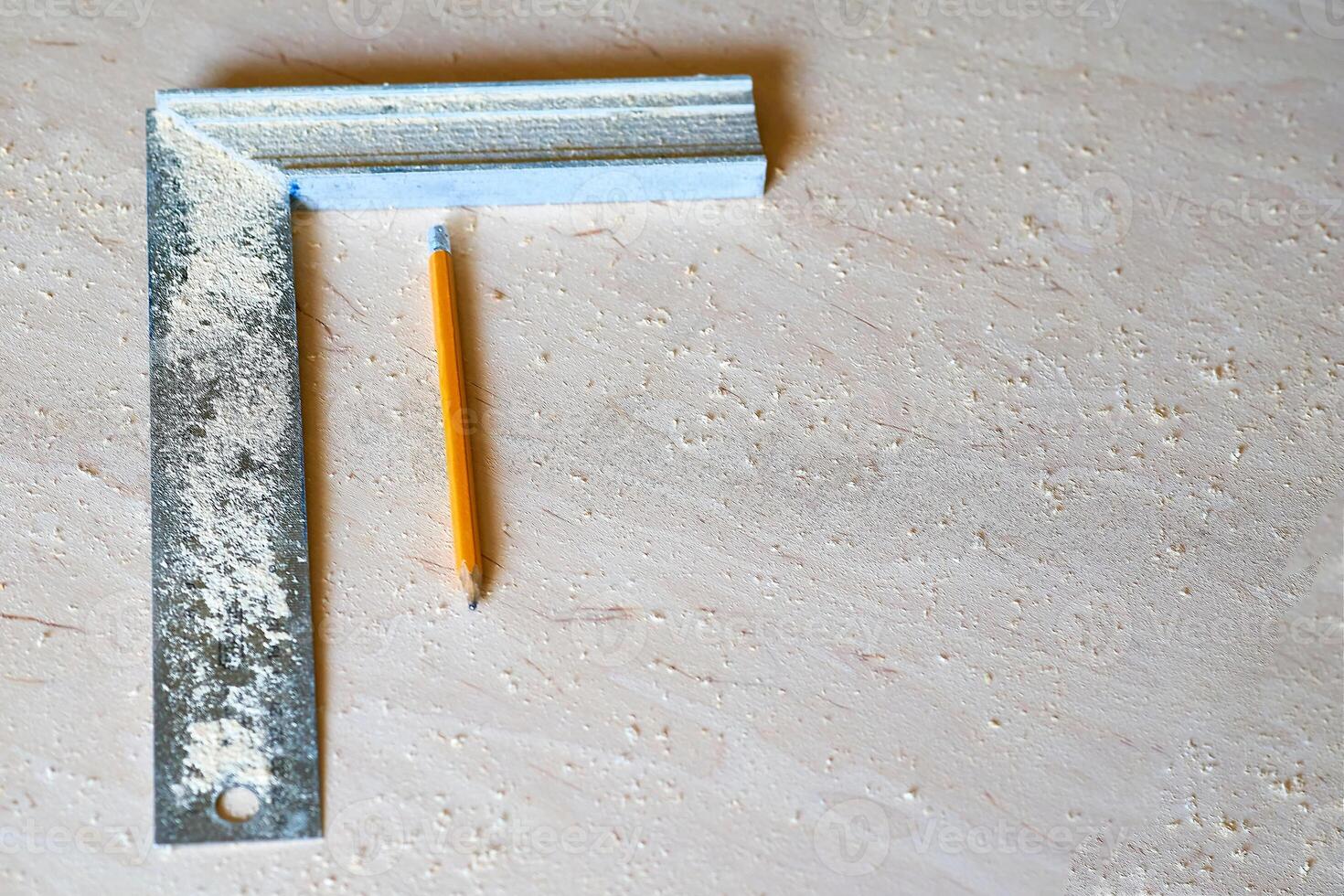Angular ruler,pencil on a sheet of plywood with sawdust photo