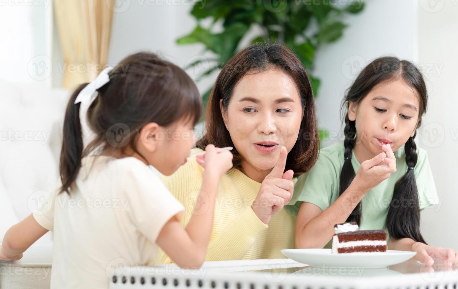 Happy young mother with daughter relaxing together in living room, Asian mom enjoying with child at home photo