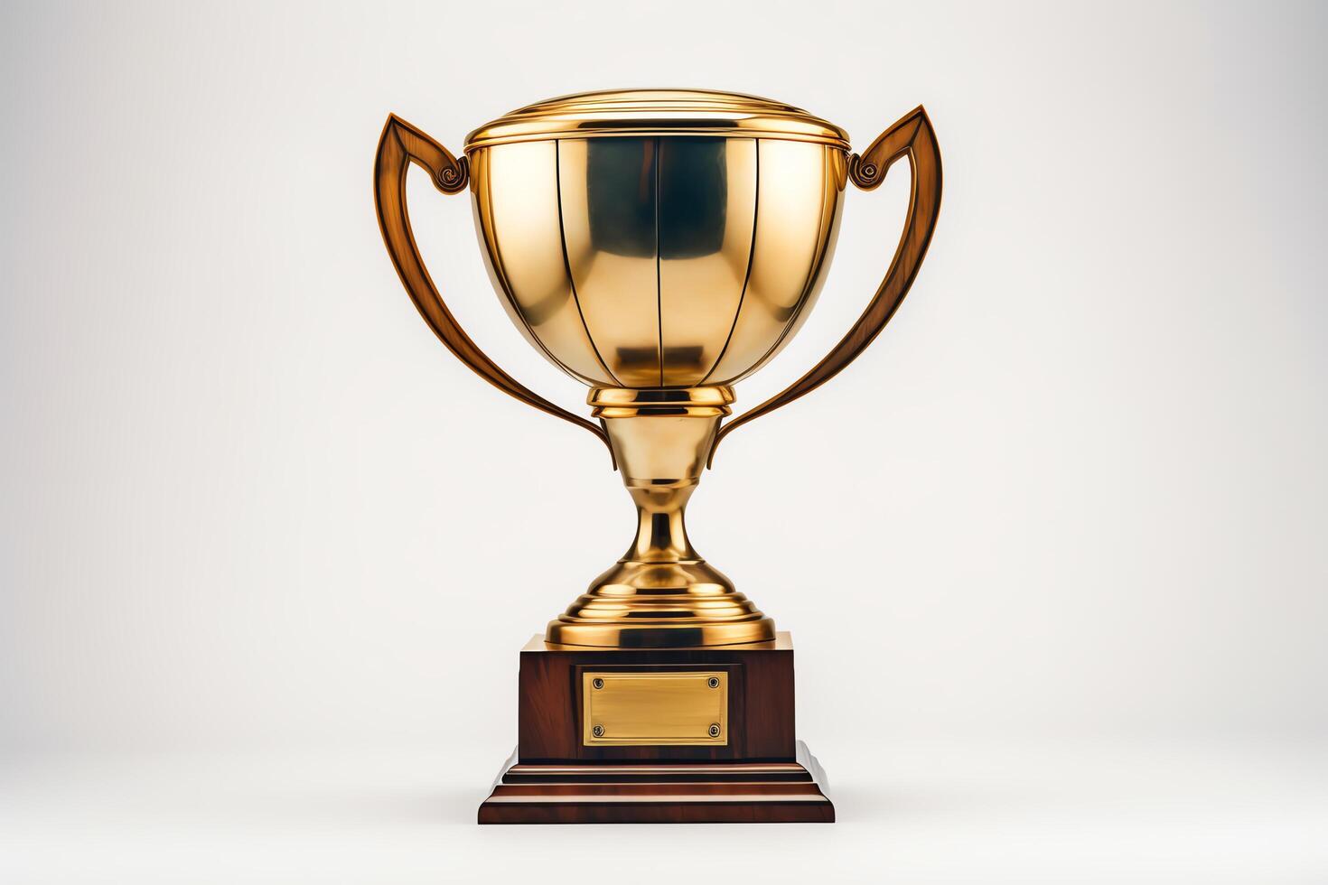 A gold trophy with a blank nameplate sits on a wooden base. The trophy is isolated on a white background. photo