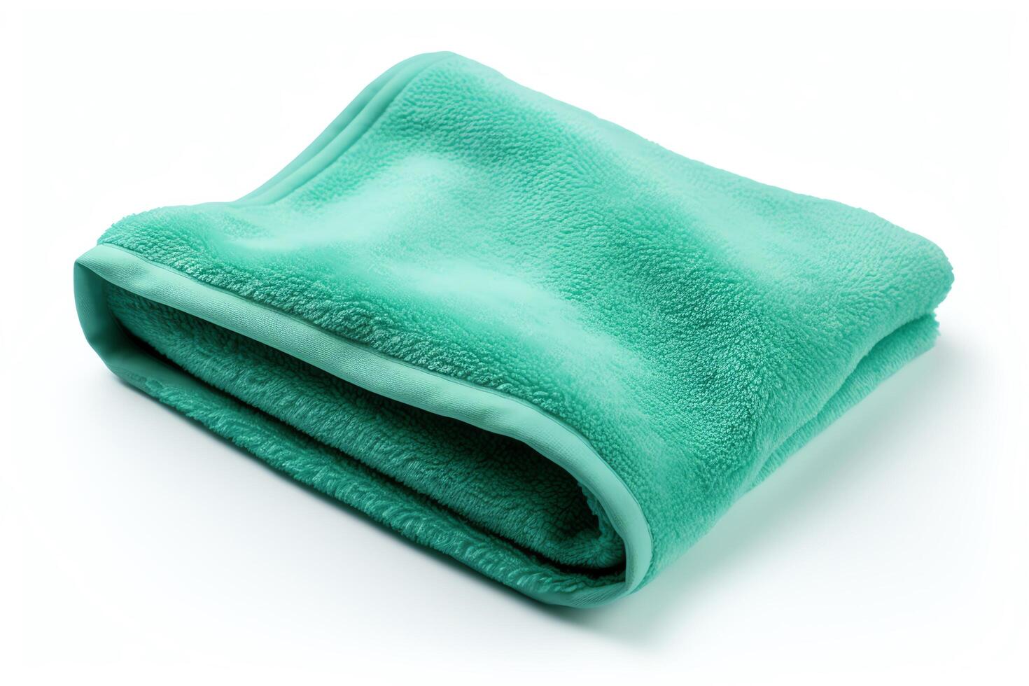 A soft, green blanket is folded on a white background. photo
