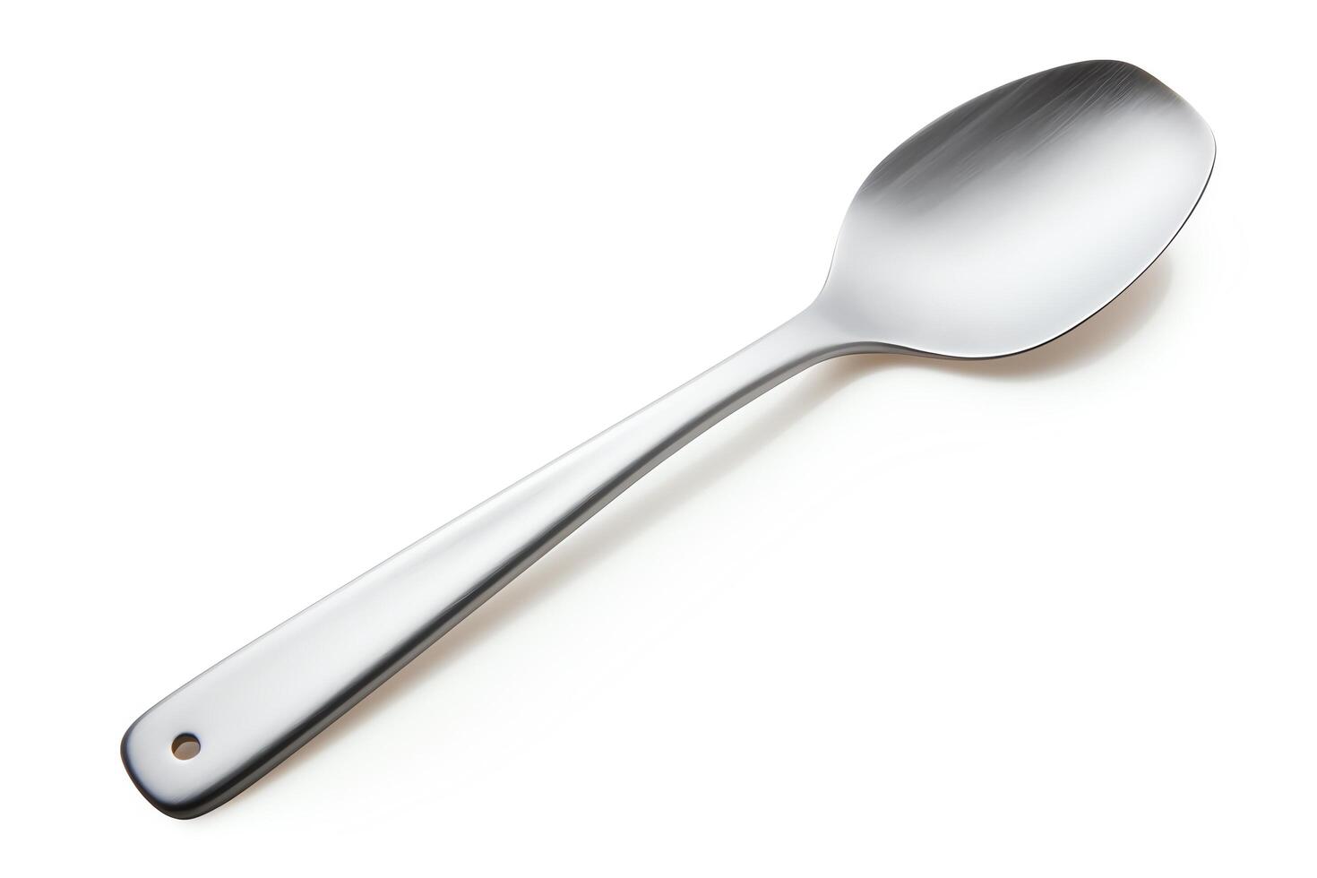 A stainless steel spoon with a round bowl and a long, thin handle. The spoon is isolated on a white background. photo