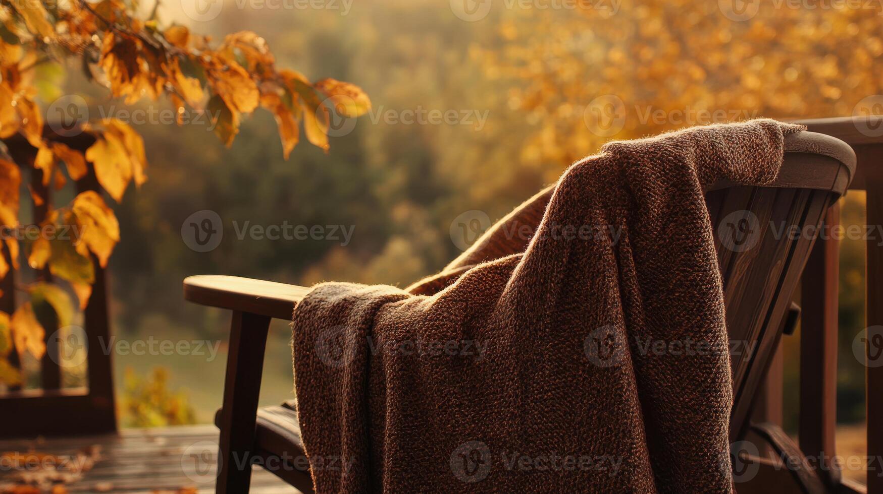 Cozy autumn scene with a poncho on a chair, earthy tones blending with the natural autumn setting, warm and inviting atmosphere. Autumn clothing photo