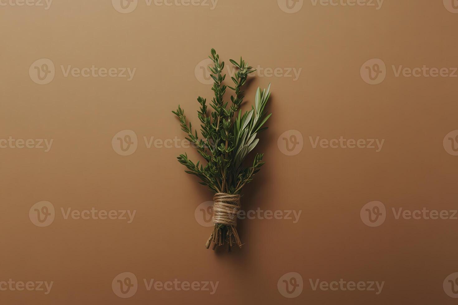 An isolated bundle of dried herbs tied with natural twine rests gracefully on a warm, earthy surface. The arrangement highlights the intricate textures and subtle colors of the herbs. photo