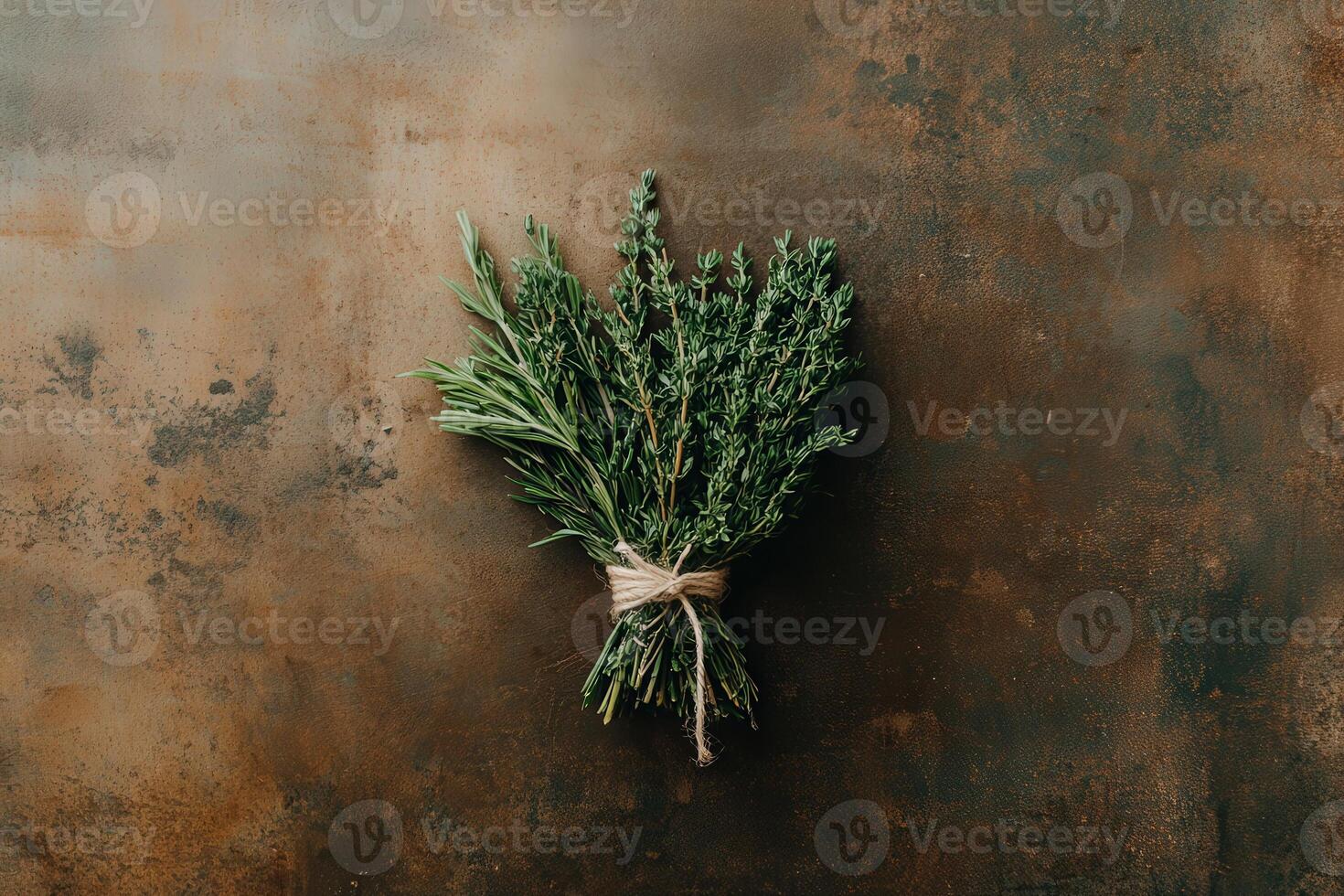 A carefully crafted bundle of dried herbs, tied together with twine, rests gracefully on a rustic wooden surface. Its earthy colors evoke a sense of natural beauty and simplicity. photo