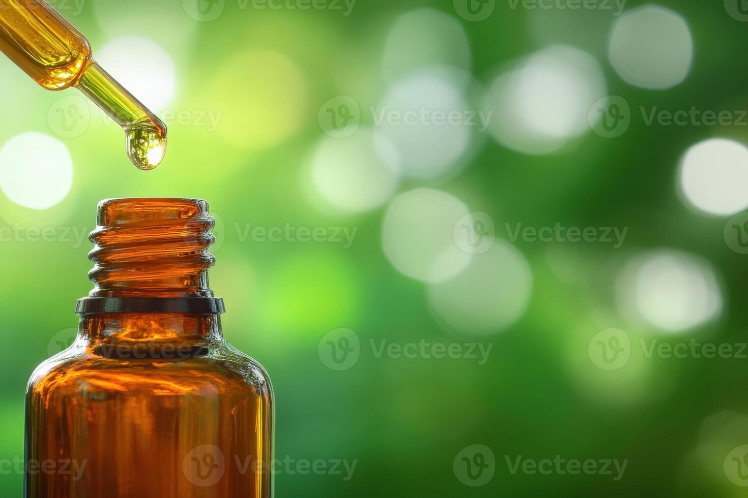 A single amber glass bottle stands out, showcasing delicate oil droplets poised at the tip of a dropper photo