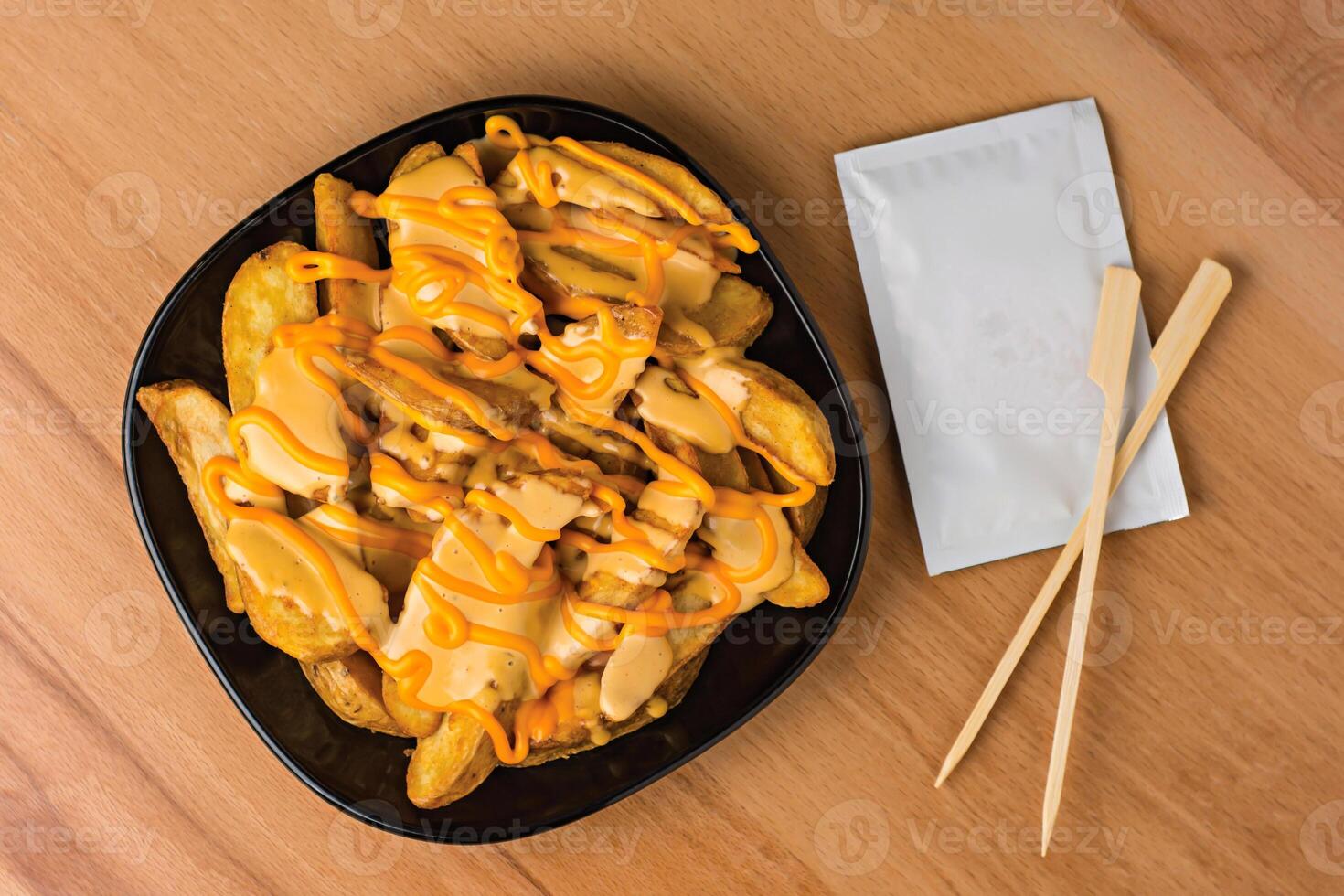 Cheesy Potato Wedges with Dipping Sauce served in plate isolated on wooden table top view fast food snacks photo