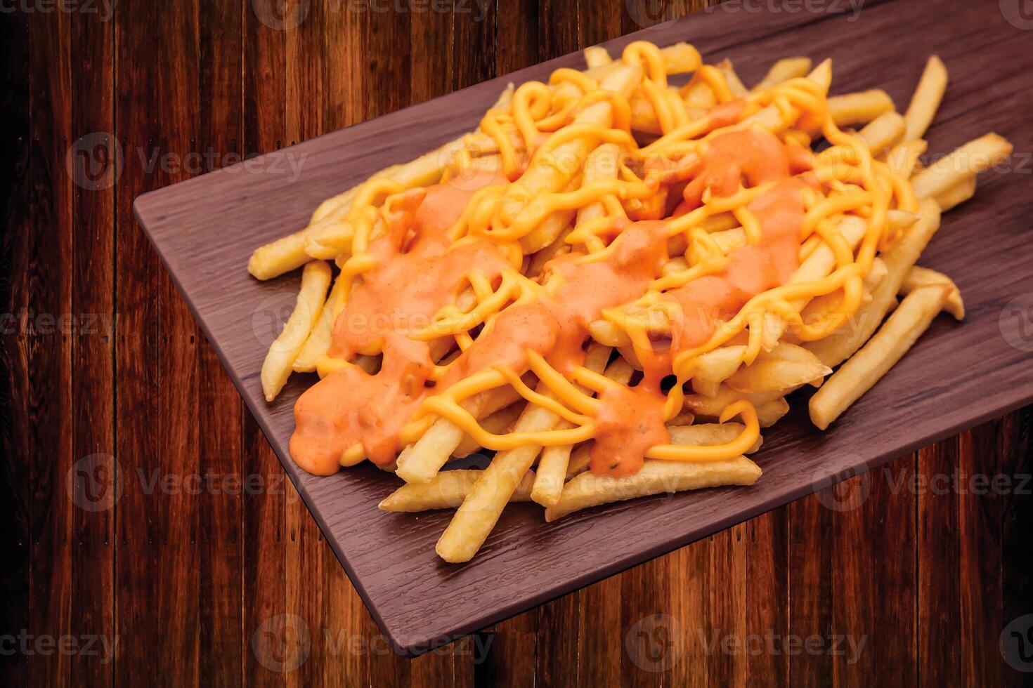 Cheesy Loaded Fries with Melted Cheese and Seasoning Sauce served on wooden board side view of fast food snacks photo