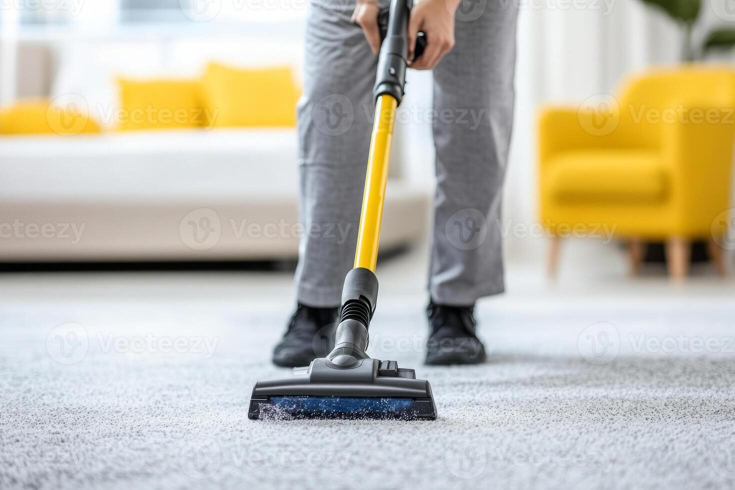 Person cleaning a carpet with a vacuum cleaner in a bright modern bedroom photo