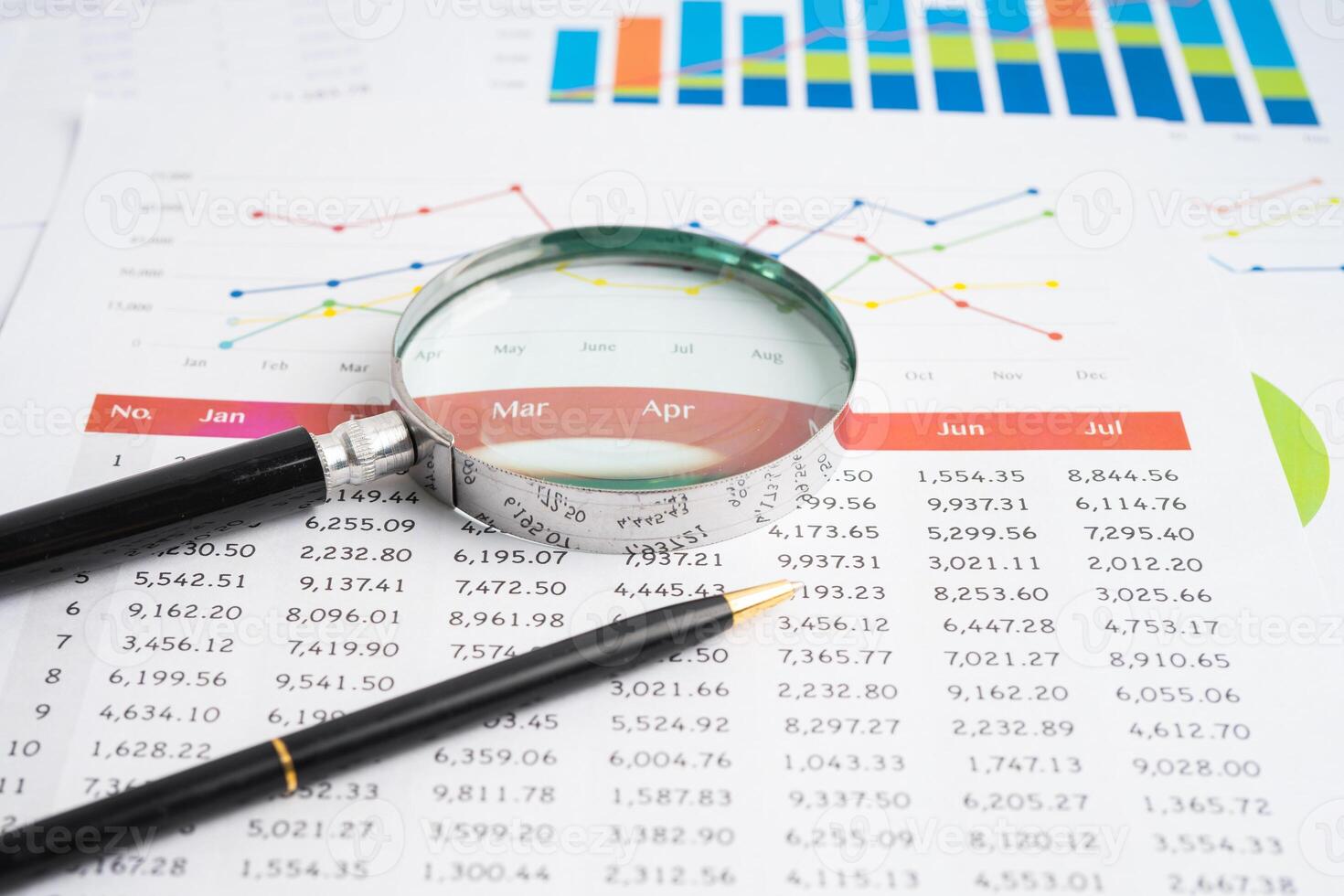 Magnifying glass on spreadsheet and graph paper. Financial development, Banking Account, Statistic, Investment Analytic research data economy, Business. photo
