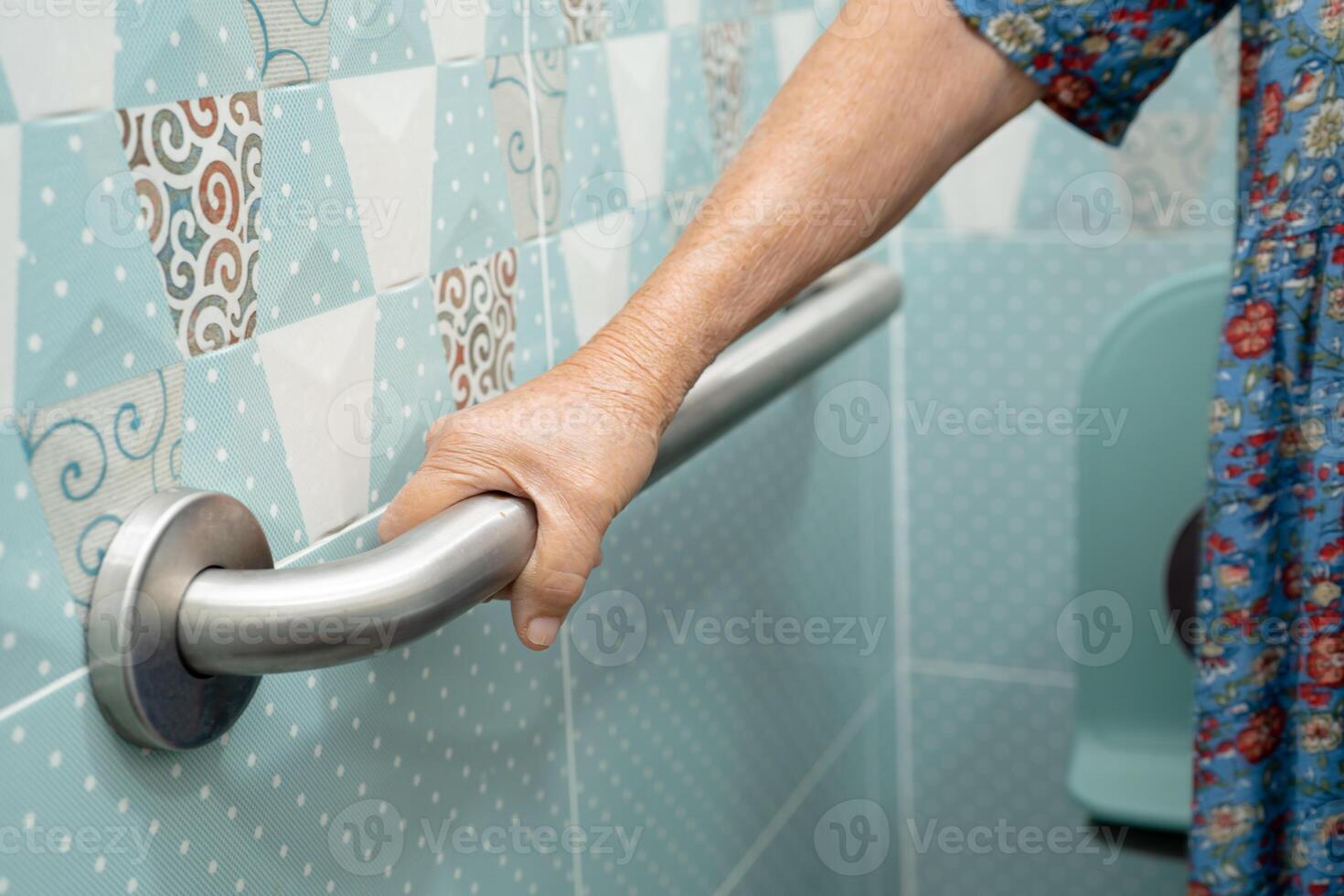 Asian elderly woman patient use toilet bathroom handle security in nursing hospital, healthy strong medical concept. photo