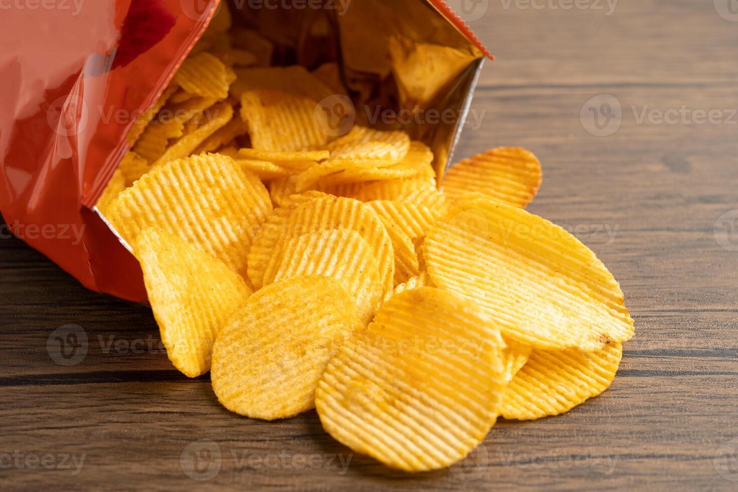 Potato chips, delicious BBQ seasoning spicy for crips, thin slice deep fried snack fast food in open bag. photo