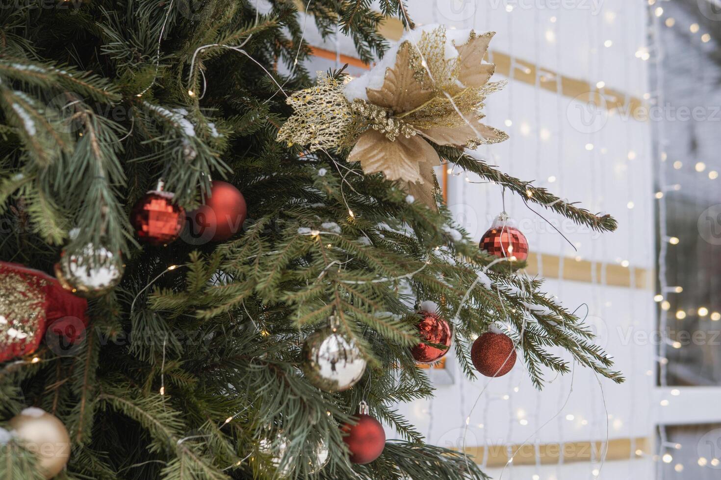 Christmas trees decorated with red balloons in front of the cafe entrance. Street New Year decorations. photo