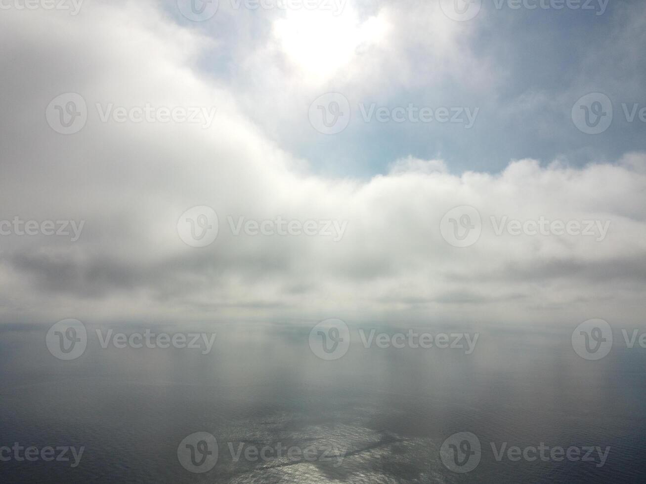 Aerial view. The drone flies over foggy and fluffy clouds. Blue sky sun and sea fog. Abstract aerial nature summer ocean sunset sea and sky background. Vacation, travel and holiday concept photo