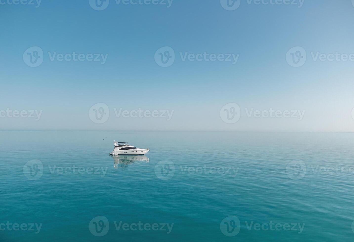 Aerial yacht on calm sea. Luxury cruise trip. View from above of white boat on deep blue water. Aerial view of rich yacht sailing sea. Summer journey on luxury ship. photo
