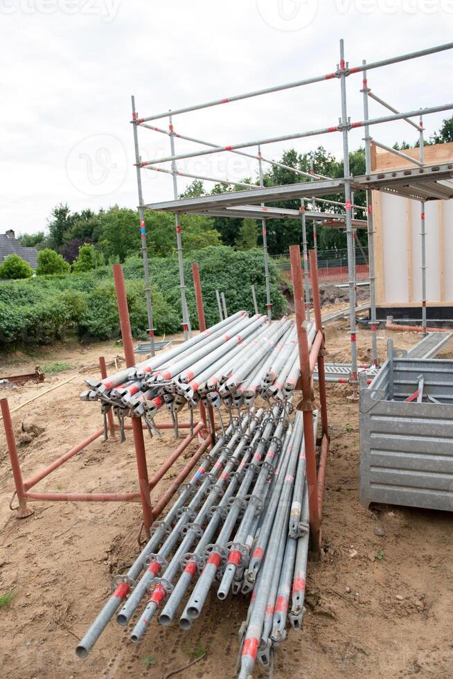 strong metal scaffolding at the construction site of a new house, the beginning of wooden structures around a metal frame. High quality photo