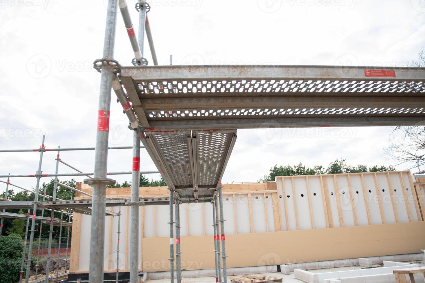 strong metal scaffolding at the construction site of a new house, the beginning of wooden structures around a metal frame. High quality photo