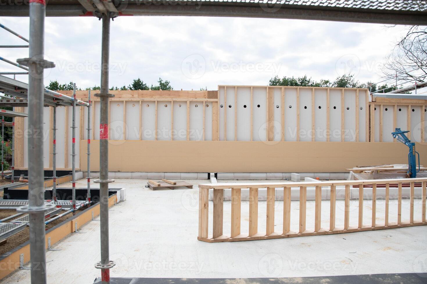 strong metal scaffolding at the construction site of a new house, the beginning of wooden structures around a metal frame. High quality photo