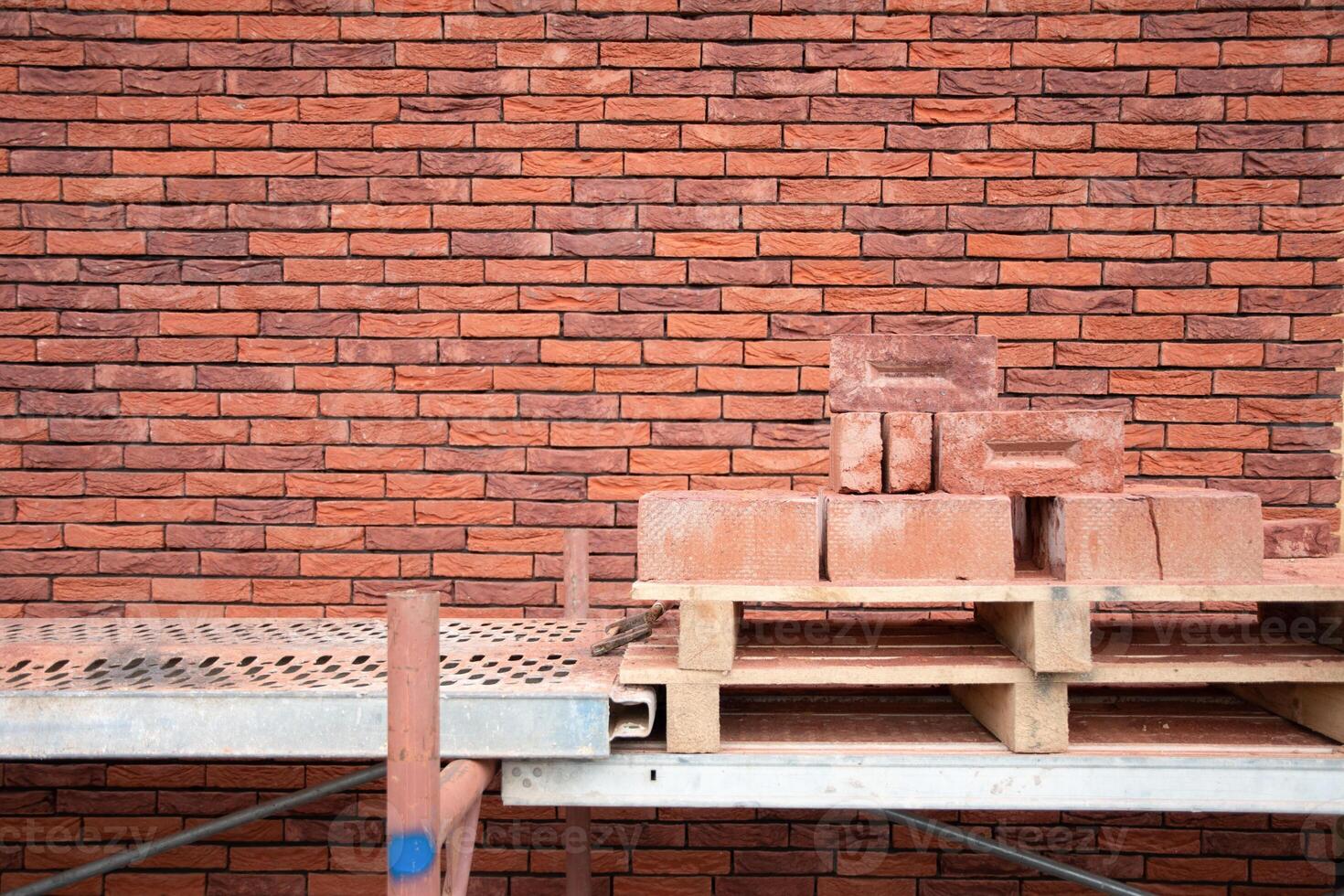 a new House is being built, the beginning of brickwork with red bricks, building materials, a pattern of stones, a natural background. High quality photo
