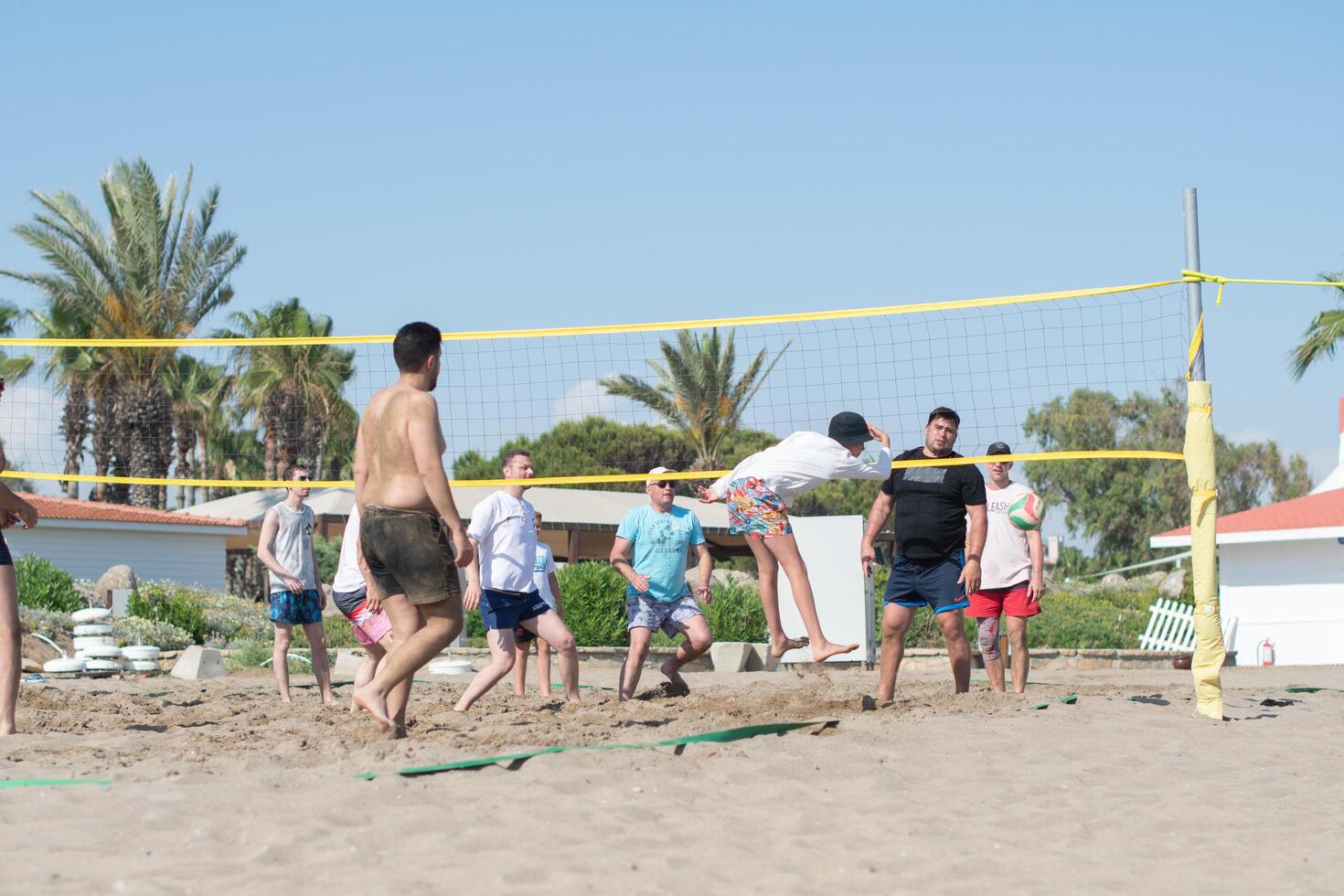 vacationing tourists of different ethnic groups play beach volleyball together on the beach by the sea during vacation, throw the ball over the net,Green Max Hotel, Belek, Turkey, May 29, 2024 photo