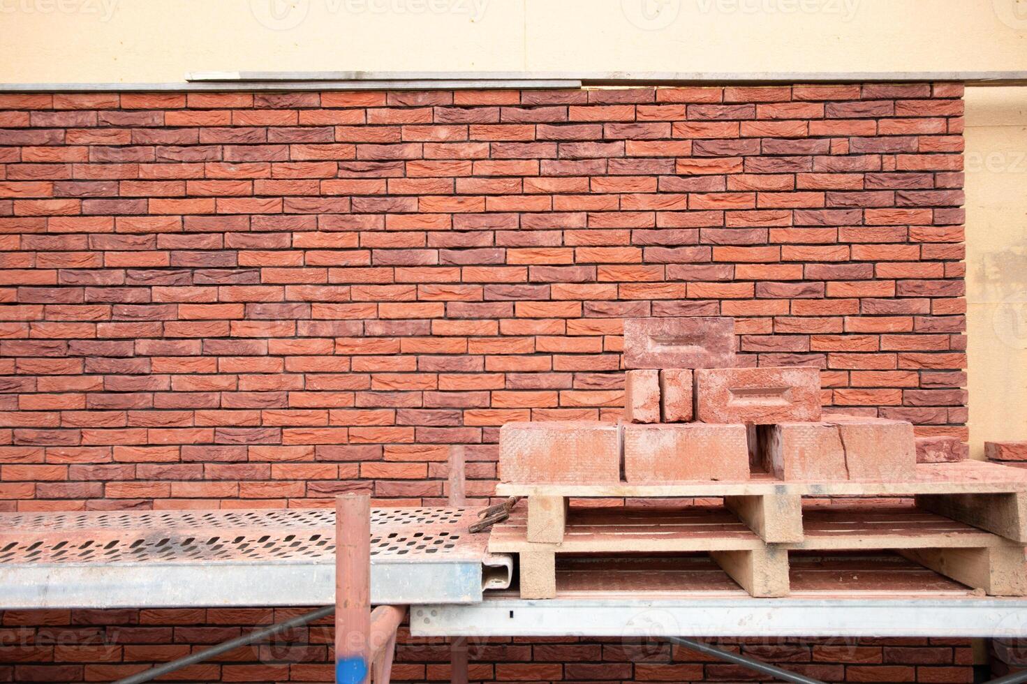 a new House is being built, the beginning of brickwork with red bricks, building materials, a pattern of stones, a natural background. High quality photo