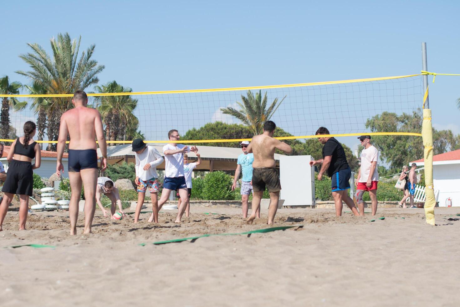 vacationing tourists of different ethnic groups play beach volleyball together on the beach by the sea during vacation, throw the ball over the net,Green Max Hotel, Belek, Turkey, May 29, 2024 photo