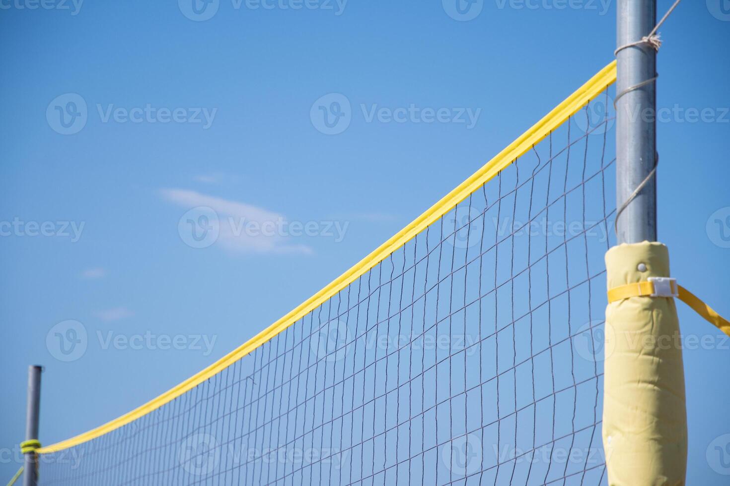 the ball flies through the net against the background of a clear blue sky, beach volleyball in the sea or ocean in summer, ball matches and active activities, copy space photo