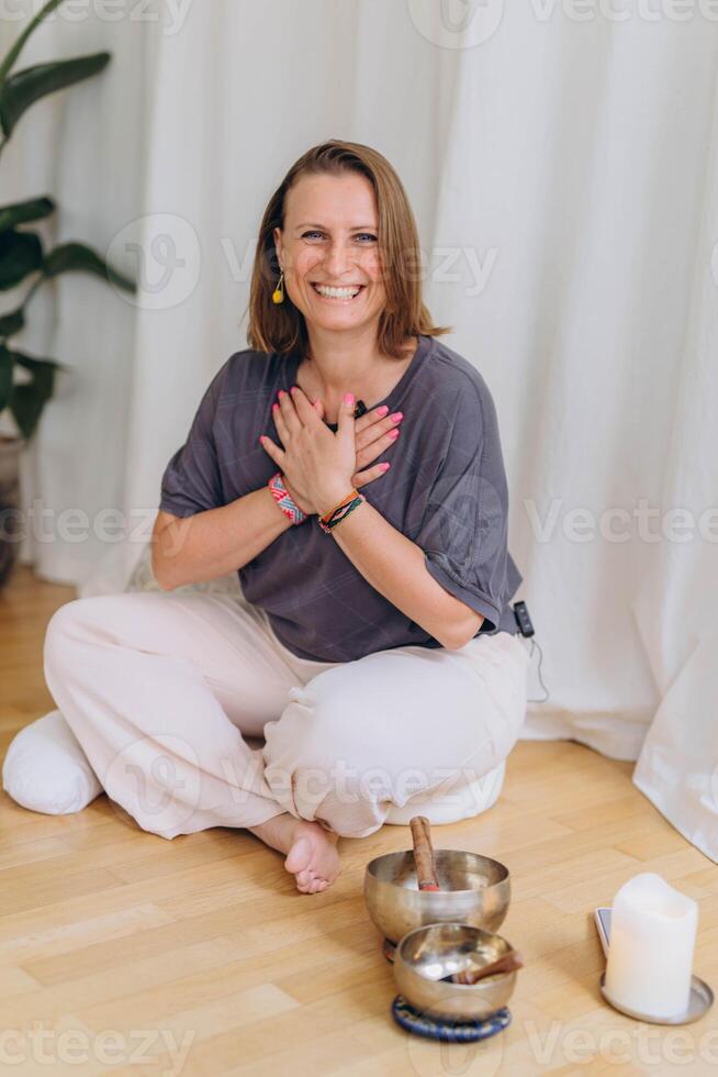 A happy woman after a breathing and singing bowl practice. photo