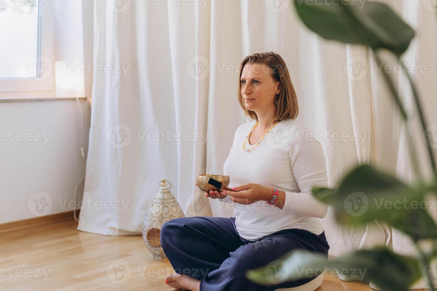 Young woman playing on a singing tibetian bowl.Relaxation and meditation.Sound therapy,alternative medicine. photo