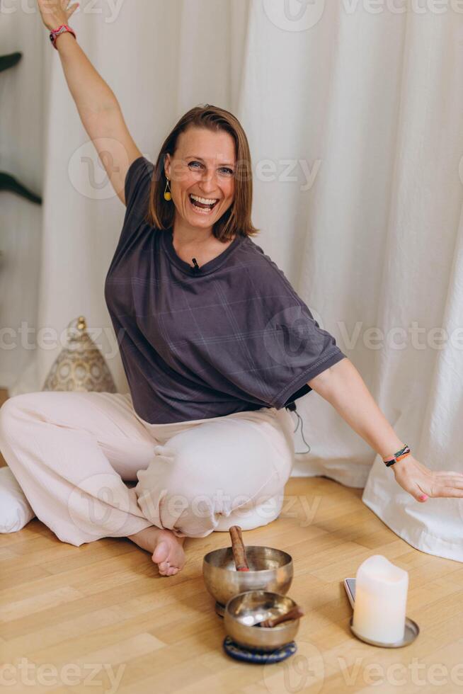 A happy woman after a breathing and singing bowl practice. photo
