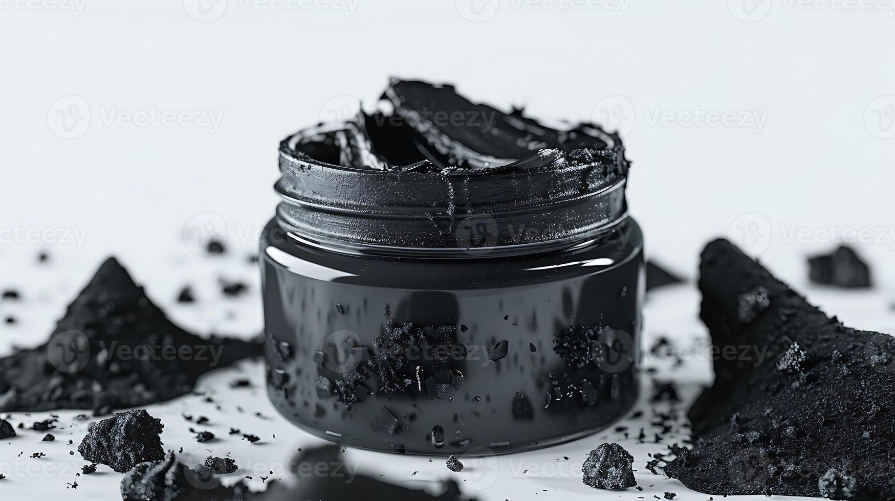 natural activated charcoal face scrub in a glass jar, showcased on a plain white background with charcoal granules. photo