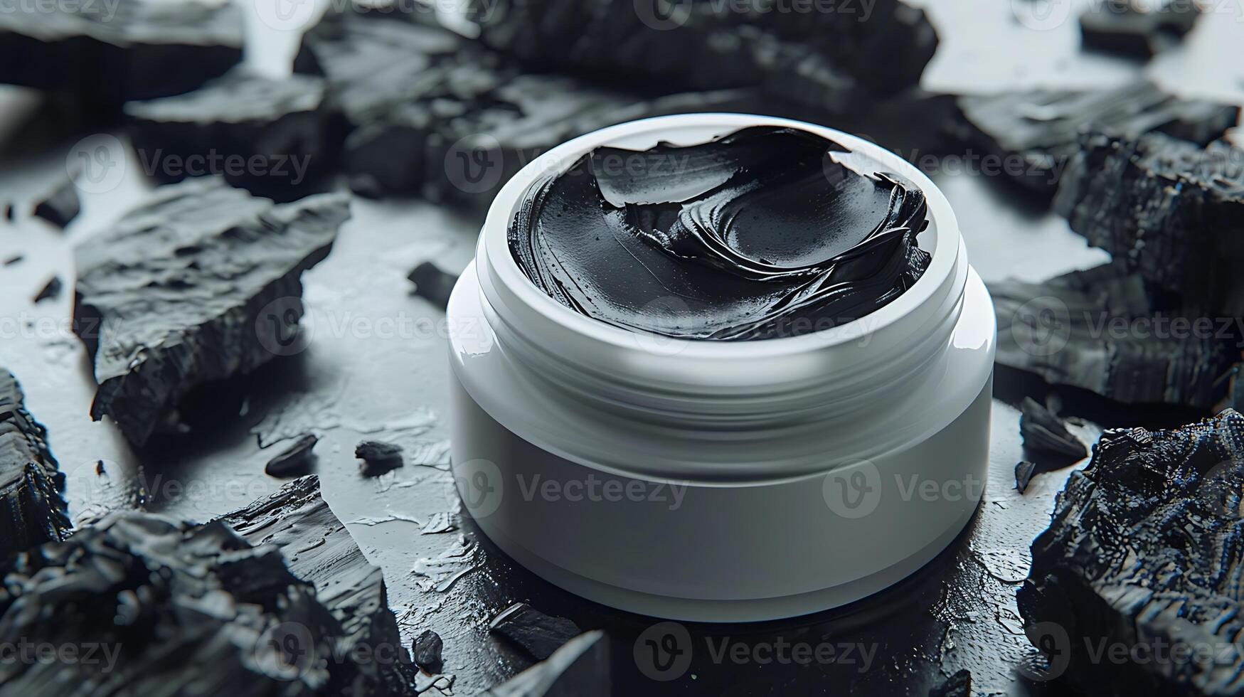 activated charcoal pieces alongside charcoal facial moisturizer in a container on a wooden table photo