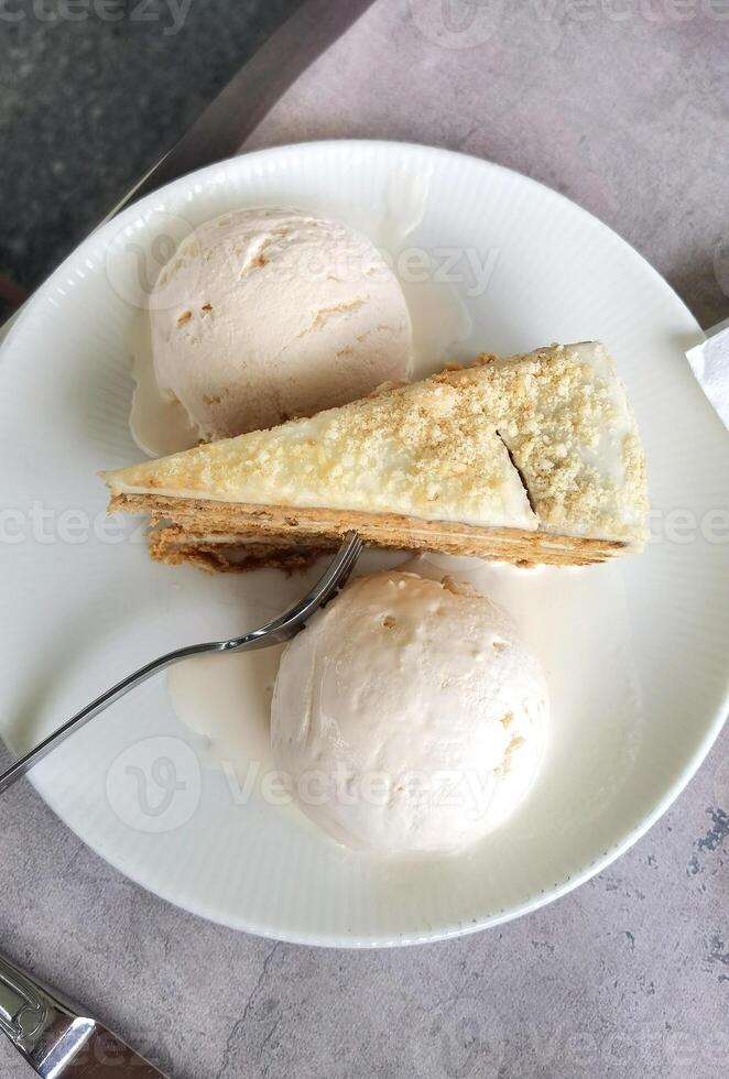 View from above of a tasty piece of cake and ice cream, on a plate with a fork photo