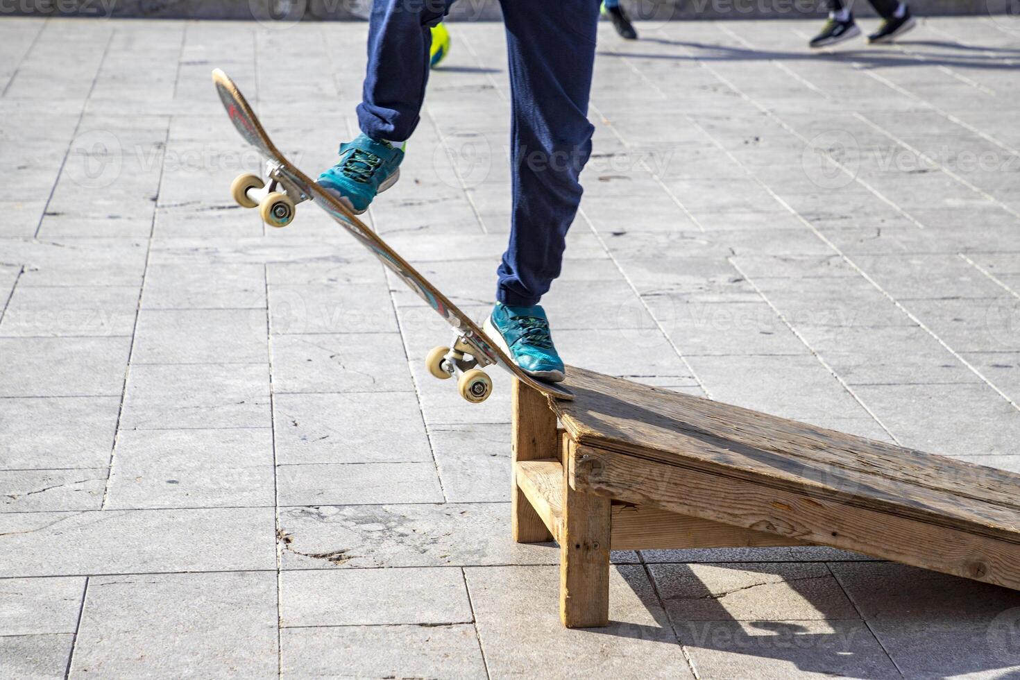 Close up view of sports legs standing on a skateboard. Riding on scateboard. Summer fun and leisure. Concept of extreme sport. photo