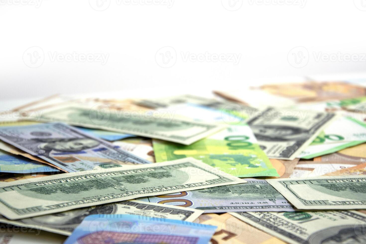 A close up image of a pile of US dollar and euro banknotes scattered on a white surface photo