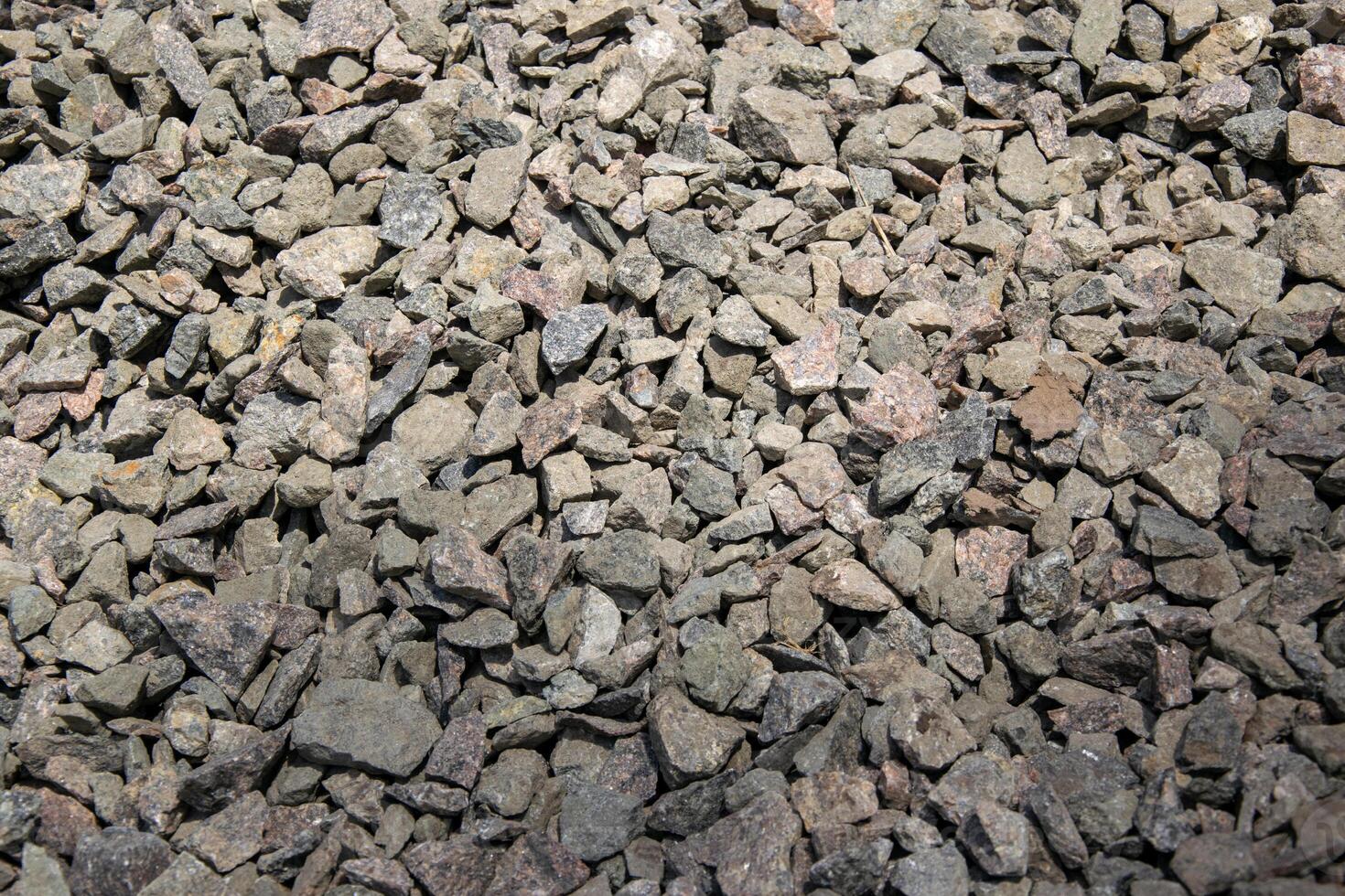 A close-up photograph of a pile of gray crushed stone gravel photo