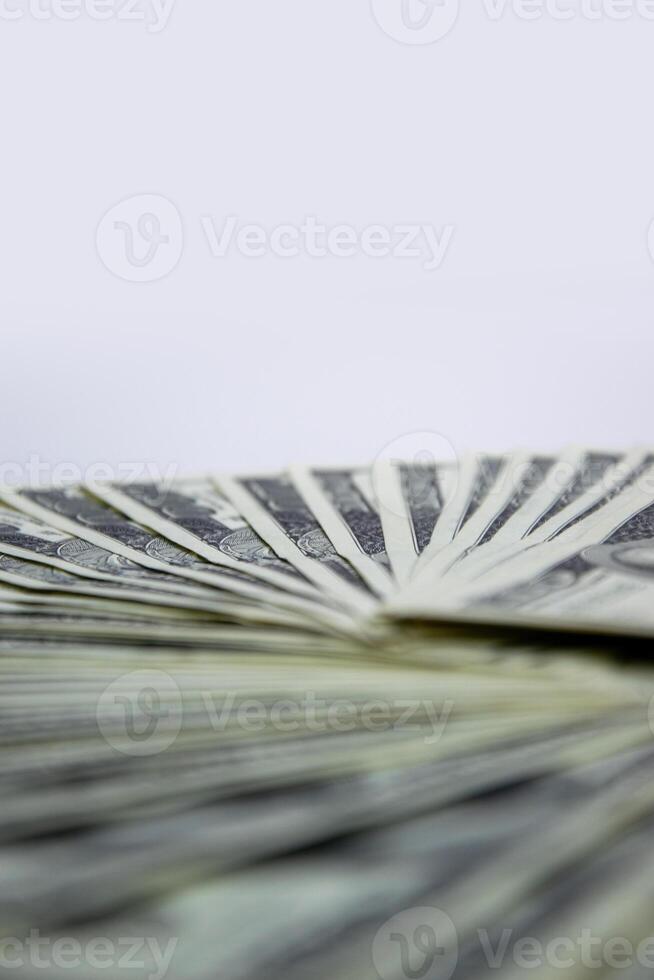 A close-up shot of several US dollar bills arranged in a fan shape, with a white background photo