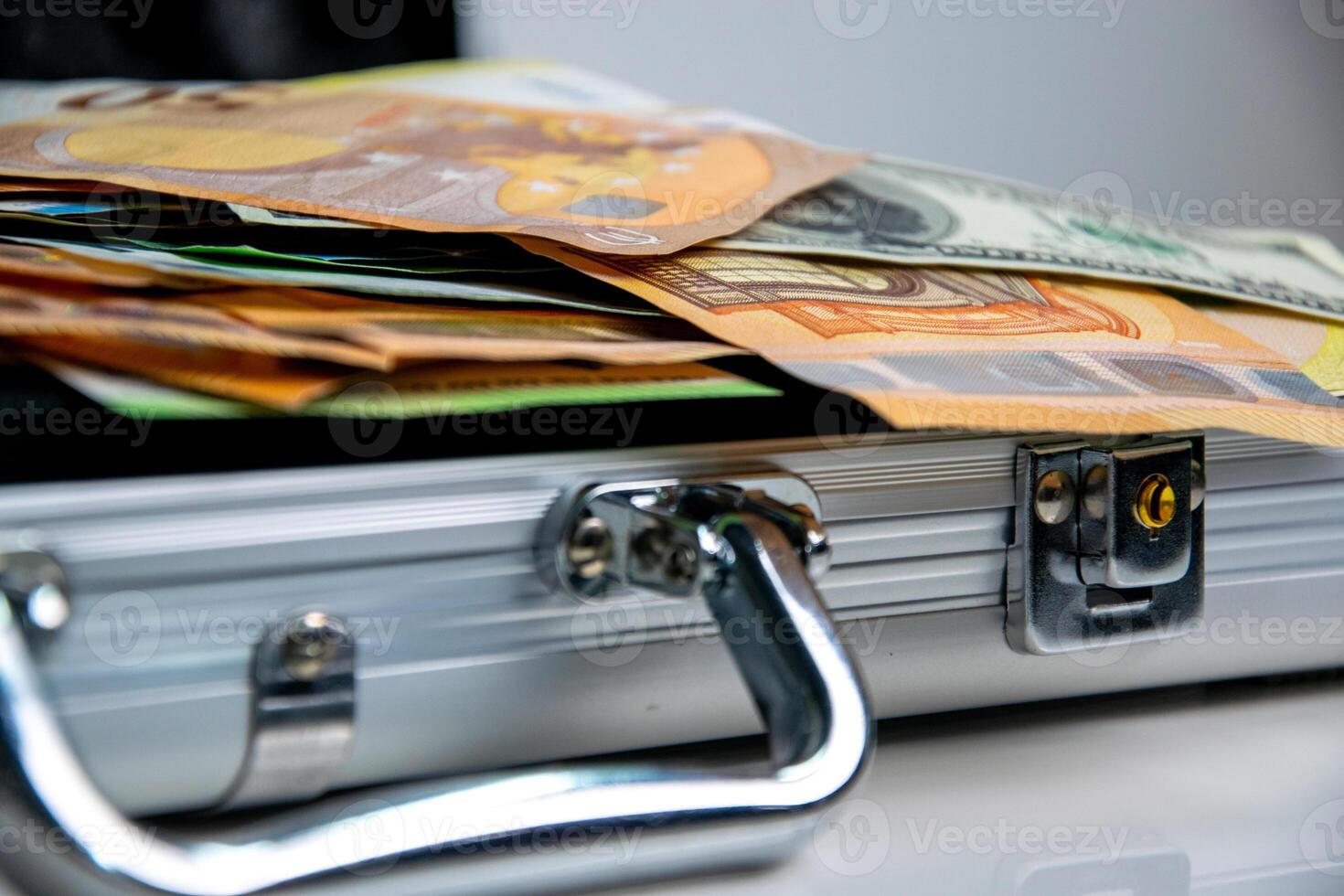 A close up image of a metal case partially open, revealing a stack of euro bills photo