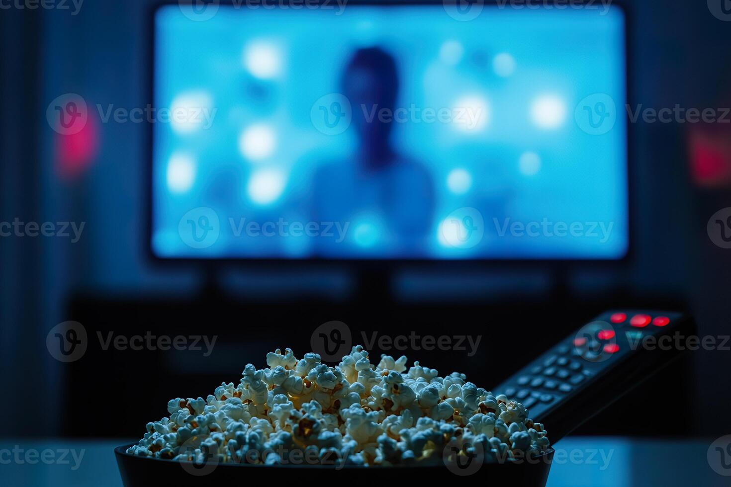 Relaxing evening with popcorn and a remote control in front of the TV. photo