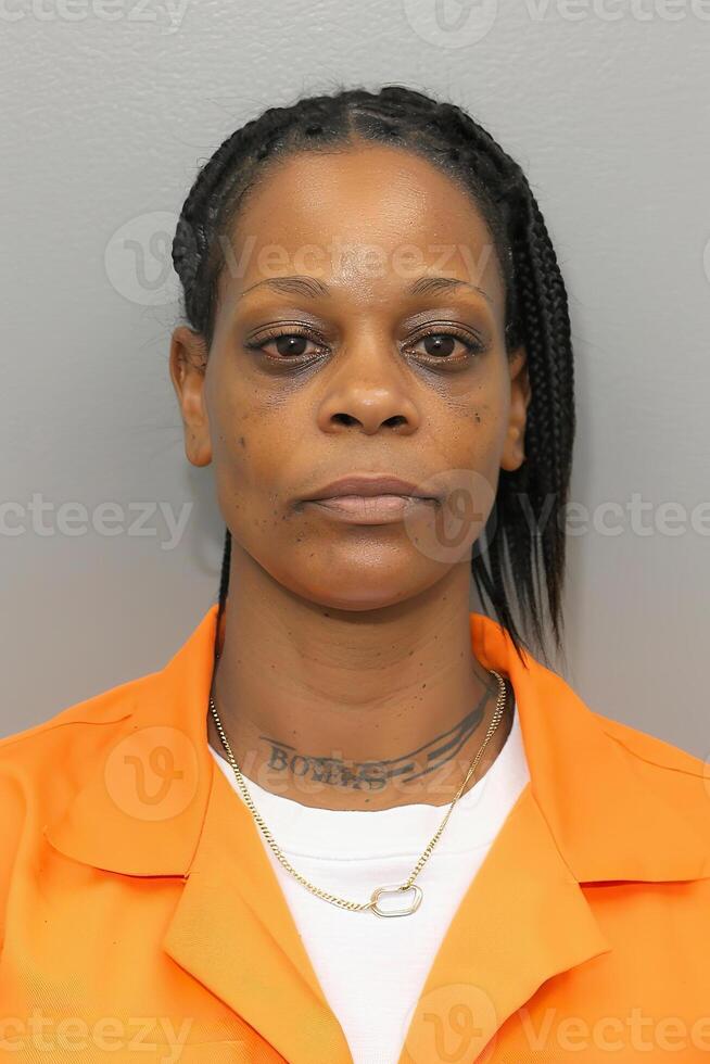 Prison mugshot of Black woman in orange jumpsuit and white shirt Prison mugshot of Black woman in orange jumpsuit and white shirt