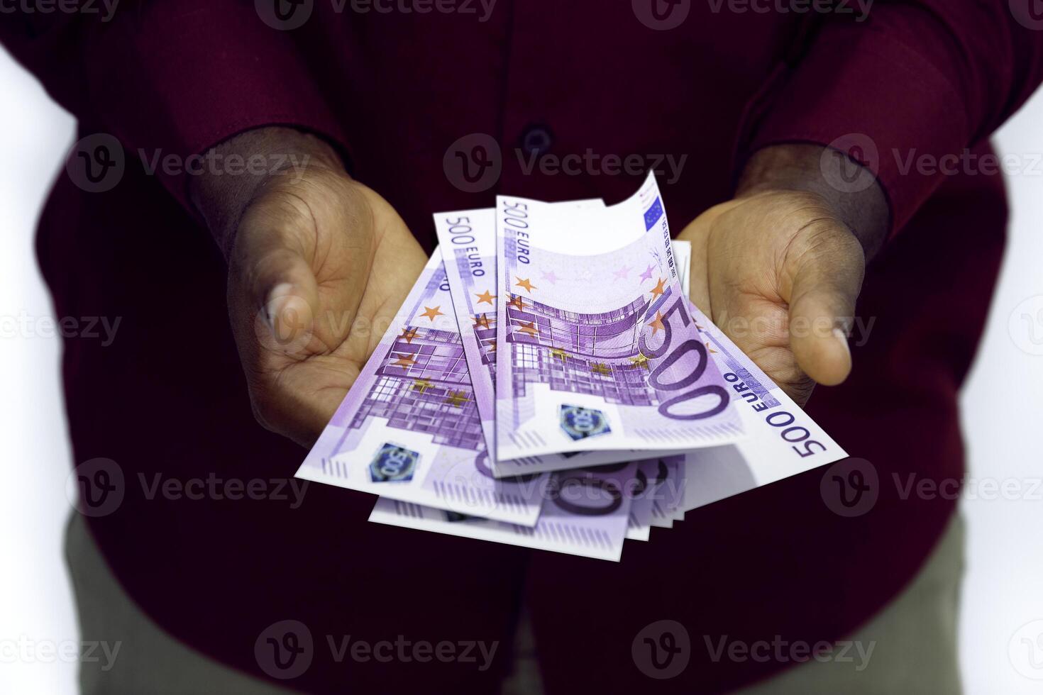 Black man in red long sleeve shirt holding 3d rendering 500 Euro notes in opened palms isolated on a white background photo
