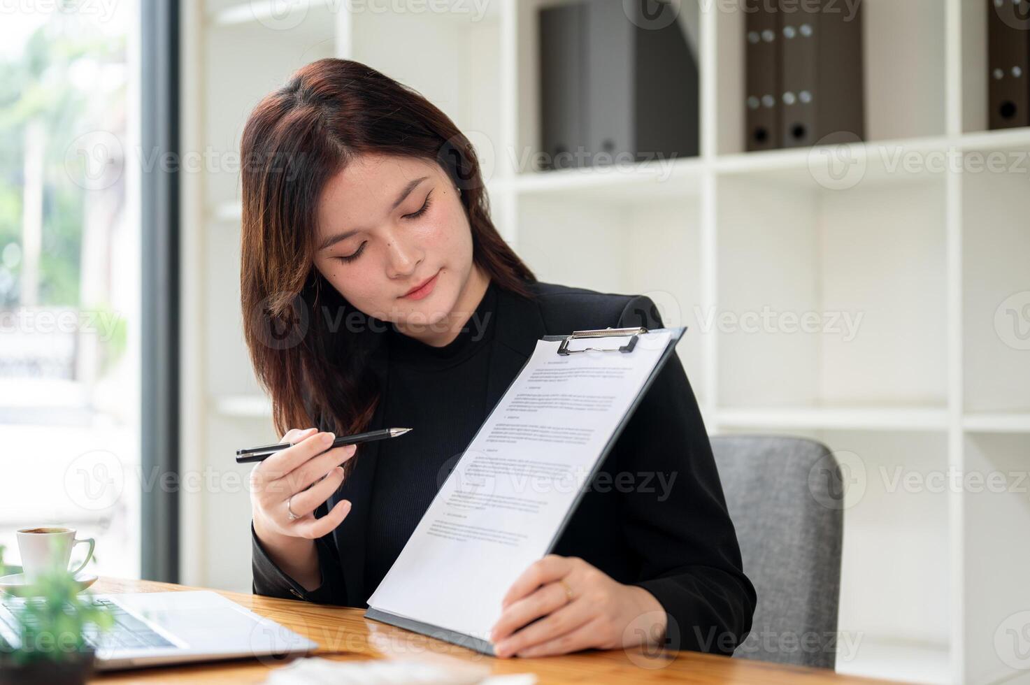 A professional female real estate agent showing and explaining a contract to a client. photo