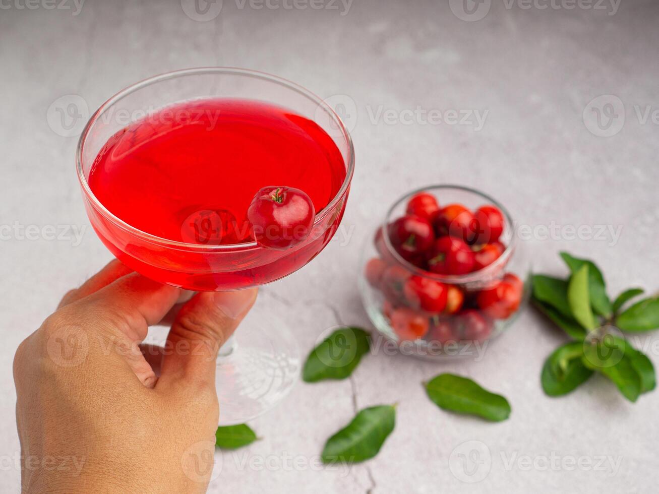 Hand holding a wine glass with cherry juice photo