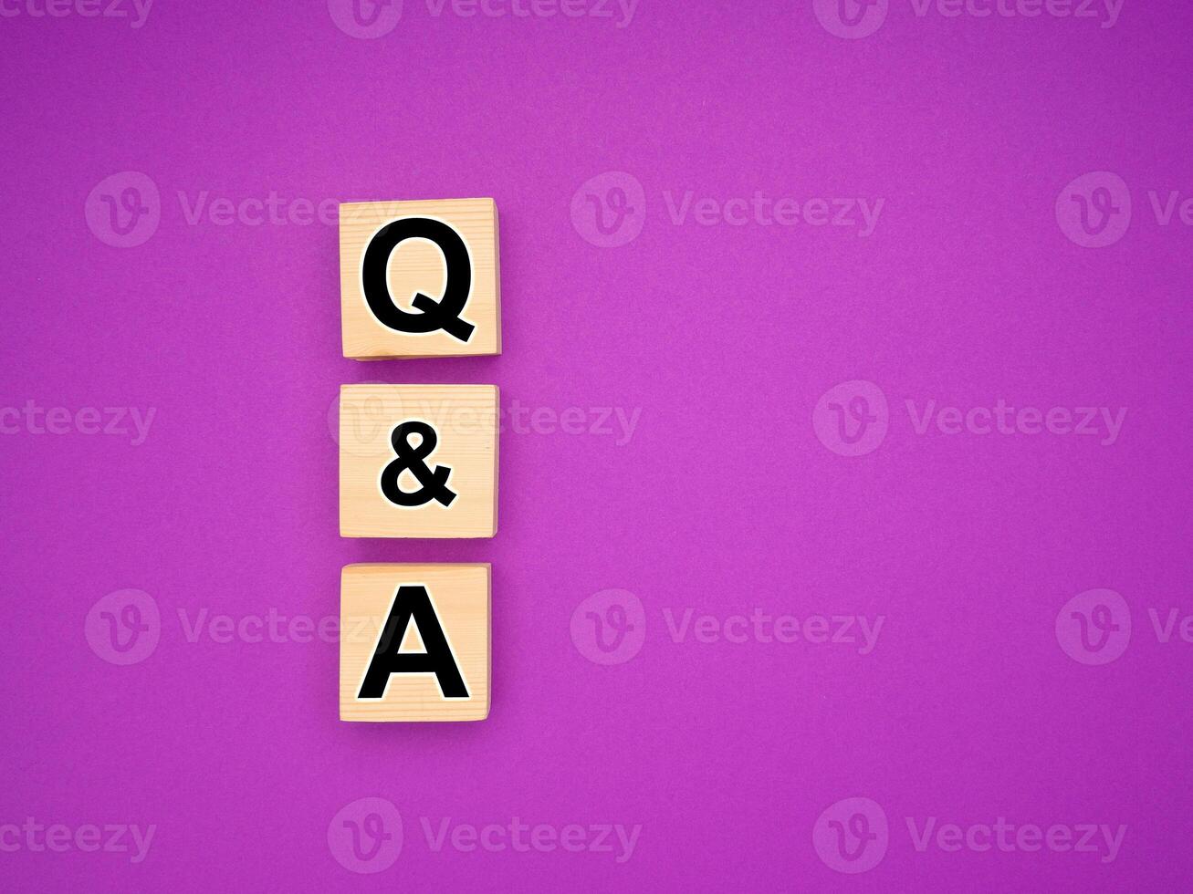 Q and A concept. Acronym from wooden blocks with letters over a purple background photo