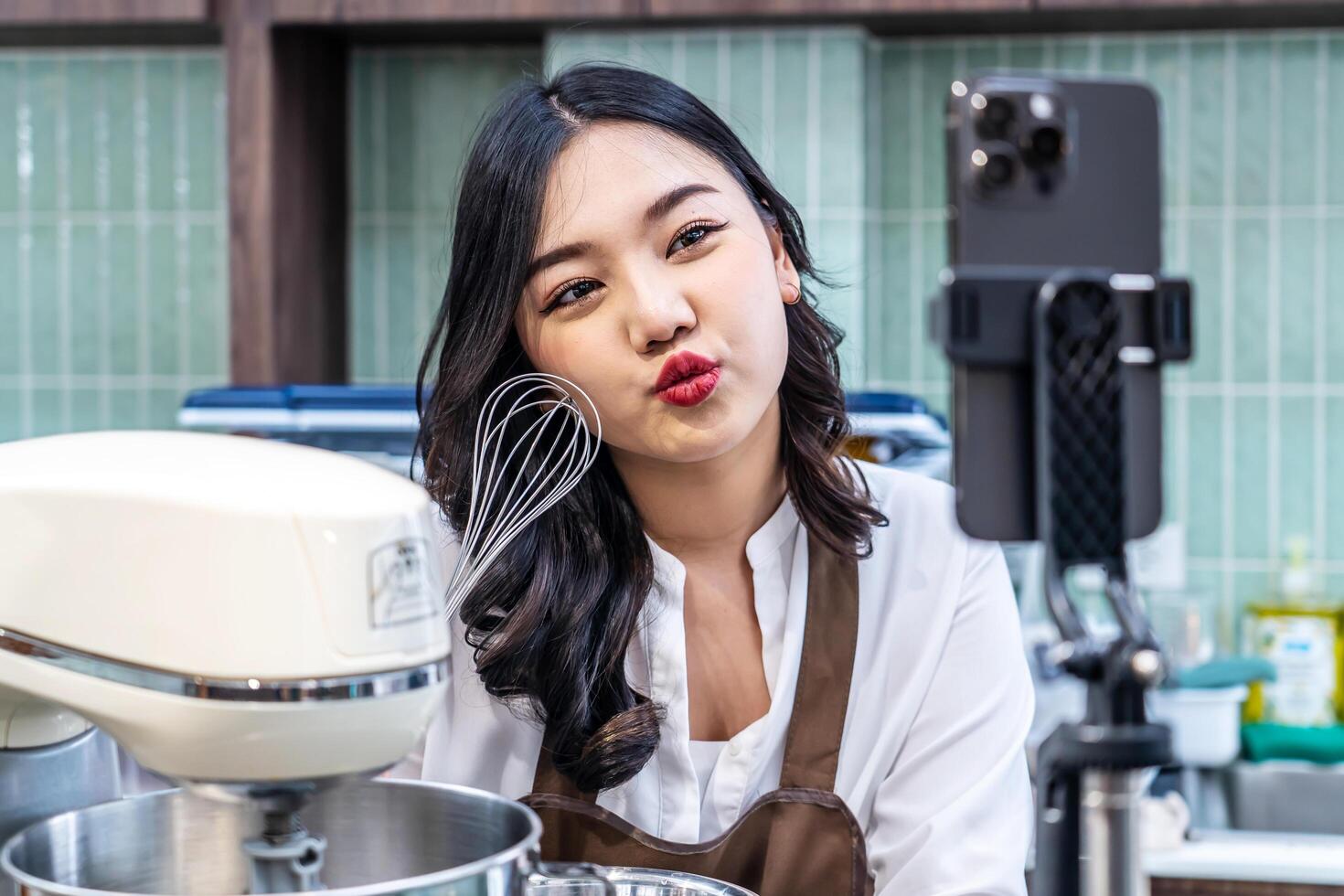 Young asian women is shop owner Put on an apron making cream for cupcakes, Using electric mixer, Preparing Cookies, Cooking, Homemade, Made specifically to sell photo